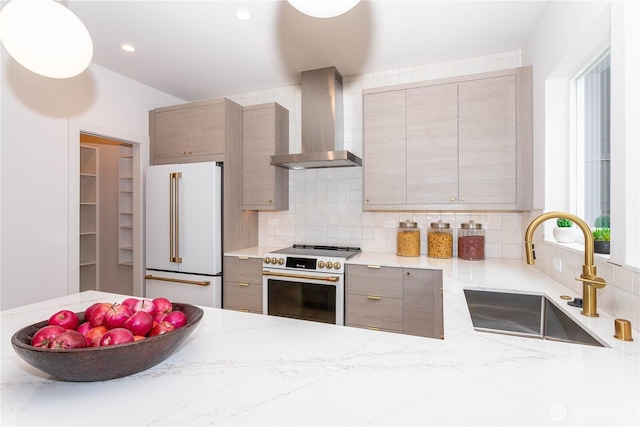 kitchen featuring white appliances, gray cabinetry, a sink, wall chimney range hood, and backsplash