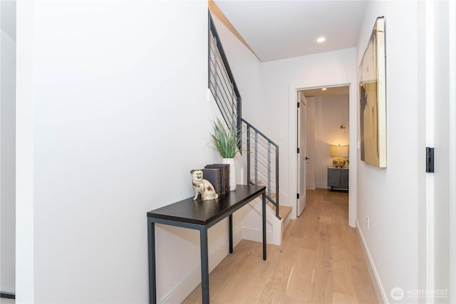 corridor with stairs, recessed lighting, baseboards, and light wood finished floors