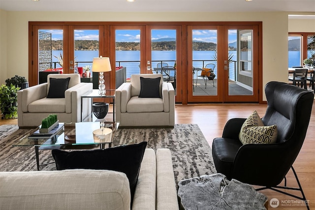 living room with a wealth of natural light, french doors, a water view, and wood finished floors