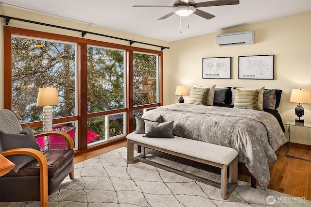 bedroom featuring ceiling fan, wood finished floors, vaulted ceiling, and a wall unit AC