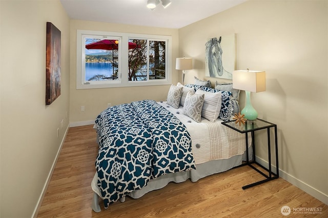 bedroom featuring baseboards and wood finished floors