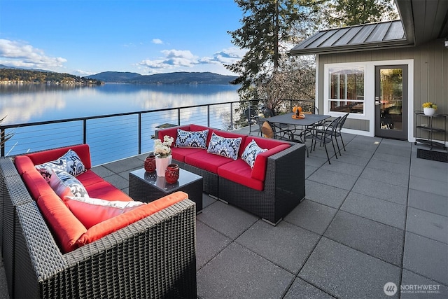 view of patio / terrace with outdoor dining space, an outdoor living space, and a water and mountain view