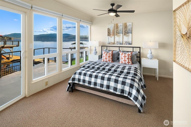 carpeted bedroom with multiple windows, a water and mountain view, and ceiling fan