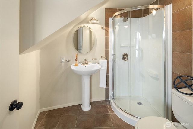 full bath with a shower stall, toilet, baseboards, and tile patterned floors