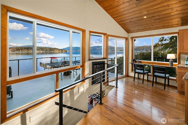 sunroom featuring a water and mountain view, wooden ceiling, and lofted ceiling