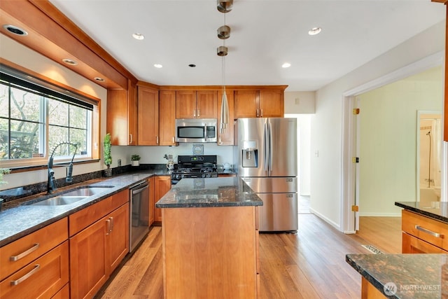 5115 S Willow St, Seattle, WA 98118 - kitchen with stainless steel appliances, a sink, a center island, light wood-style flooring, and brown cabinets