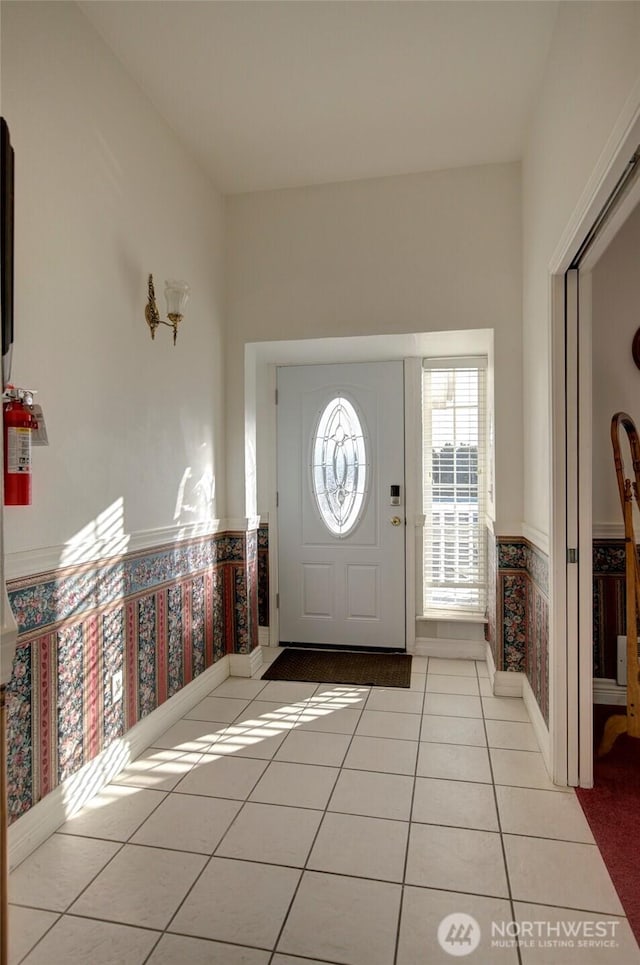 entryway featuring wainscoting and light tile patterned flooring