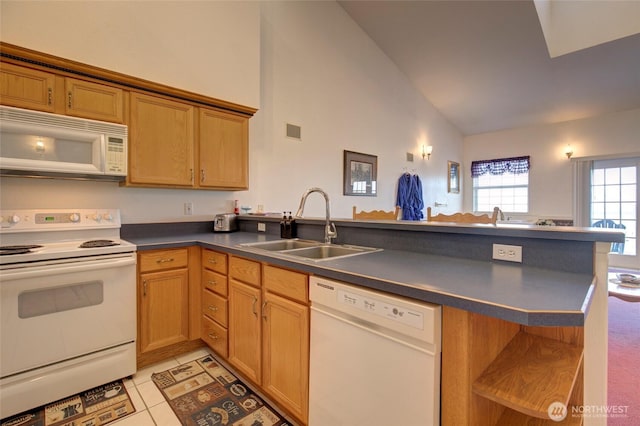 kitchen featuring white appliances, visible vents, dark countertops, a peninsula, and a sink