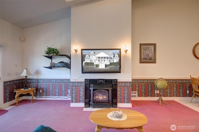 living area featuring carpet, wainscoting, a tile fireplace, and wallpapered walls