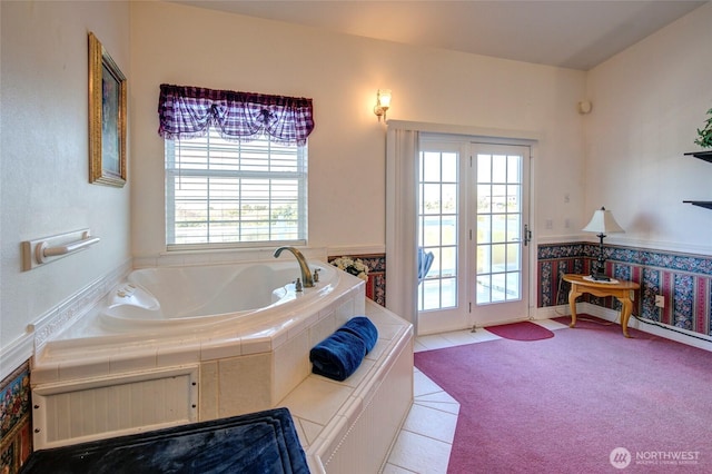 bathroom with a garden tub, tile patterned flooring, and wainscoting