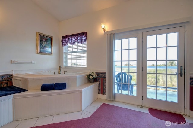 bathroom featuring tile patterned flooring, a garden tub, and lofted ceiling