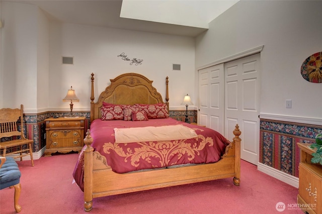 carpeted bedroom featuring a closet, wainscoting, and visible vents