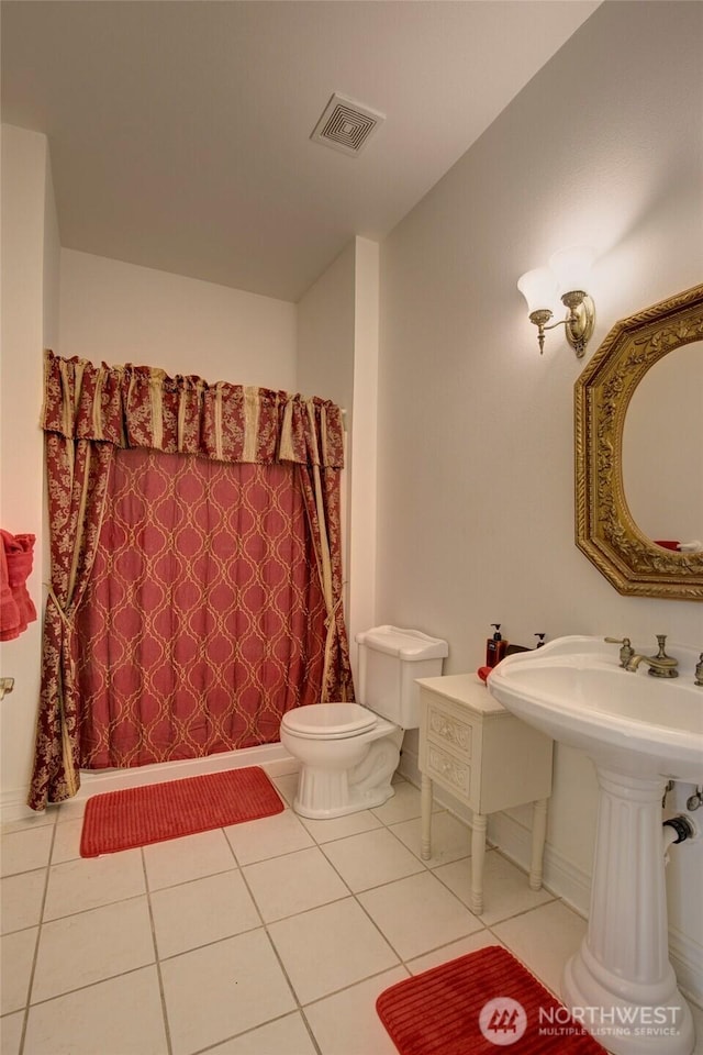 bathroom with toilet, a shower with shower curtain, tile patterned flooring, and visible vents