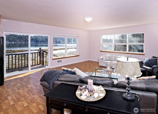 730 E N Bay Rd, Allyn, WA 98524 - living area with a water view, wood finished floors, and baseboards