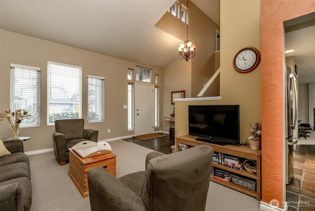 carpeted living area with a notable chandelier, high vaulted ceiling, and baseboards