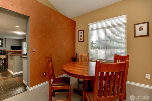 dining room with baseboards and dark colored carpet