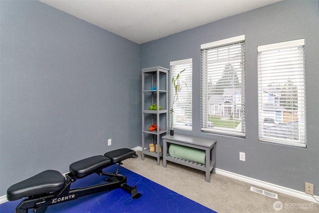 exercise area featuring visible vents, baseboards, and carpet flooring