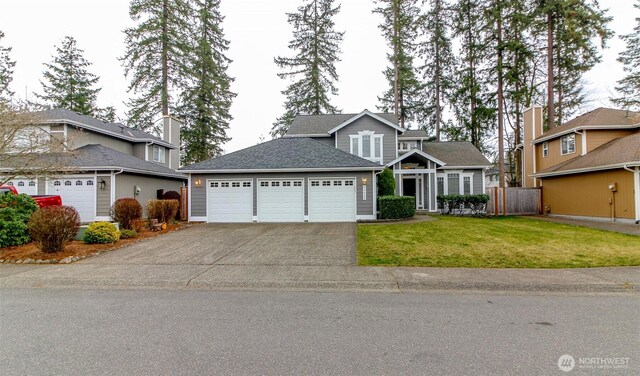 traditional home with a shingled roof, fence, a front yard, driveway, and an attached garage