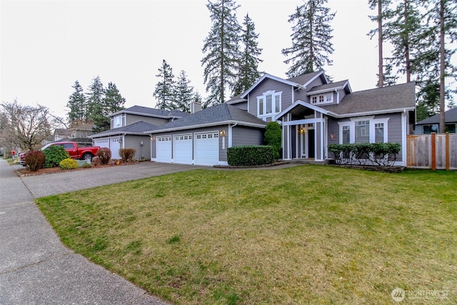 view of front of home featuring a garage, driveway, a front yard, and fence