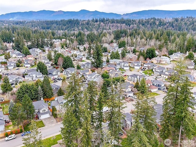 aerial view with a forest view, a mountain view, and a residential view