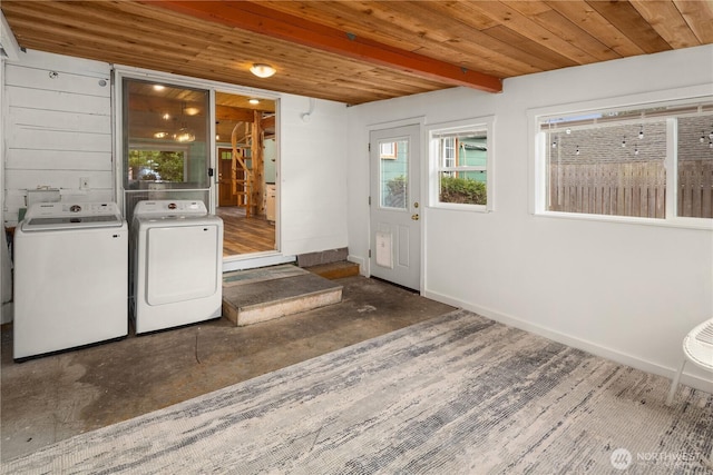 clothes washing area with washer and dryer, wood ceiling, laundry area, and baseboards