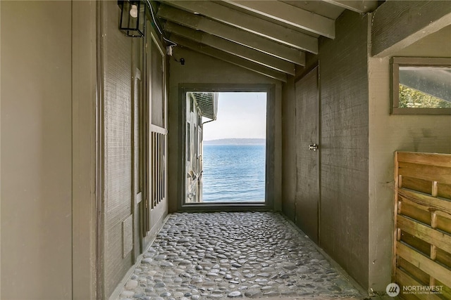 doorway with a water view and vaulted ceiling