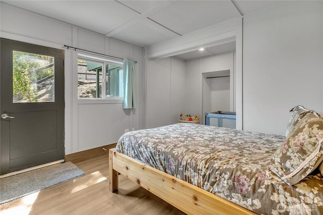 bedroom with a decorative wall and wood finished floors