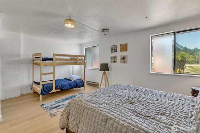 bedroom with a baseboard radiator and wood finished floors