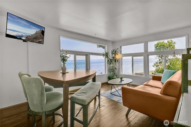 dining room featuring a water view and wood-type flooring