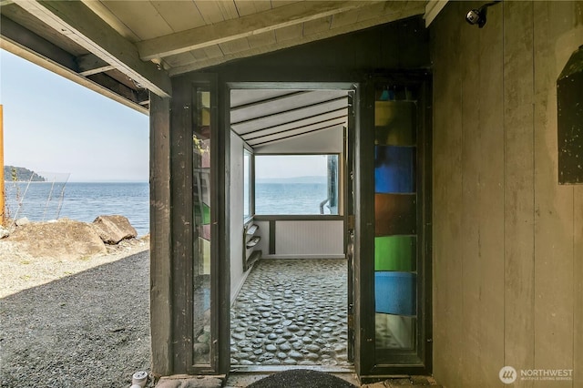 corridor with wood ceiling, lofted ceiling with beams, and a water view