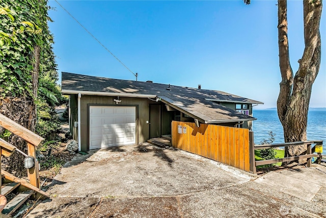 exterior space with an attached garage, driveway, and a water view