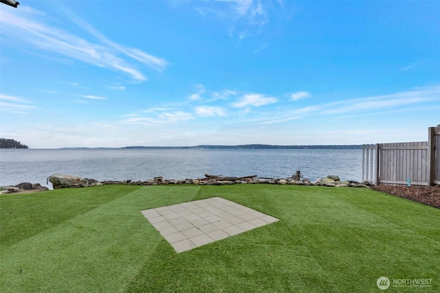 view of yard featuring a water view, a patio, and fence