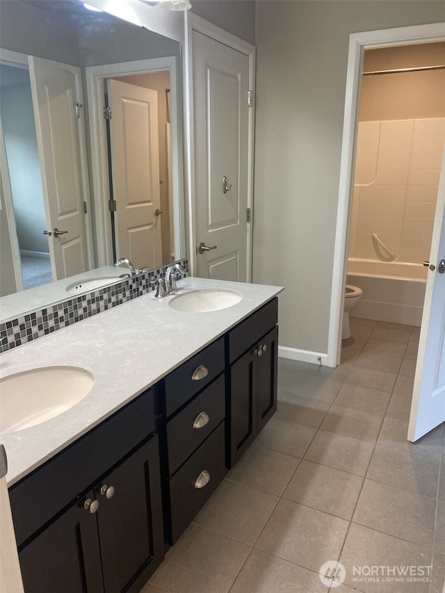 full bath with toilet, tile patterned flooring, and a sink