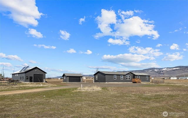 view of front of home with a garage, a mountain view, and an outdoor structure