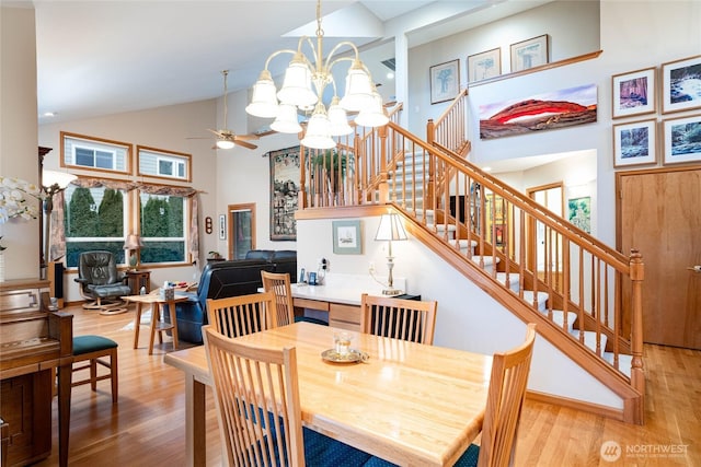 dining area with stairs, high vaulted ceiling, wood finished floors, and a wealth of natural light