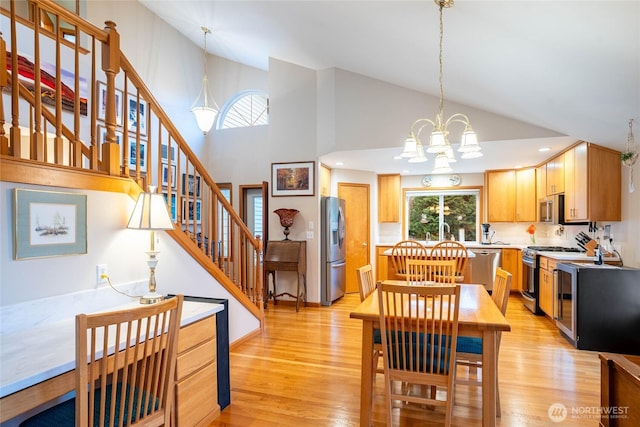 dining space featuring high vaulted ceiling, light wood-style floors, stairway, and a notable chandelier