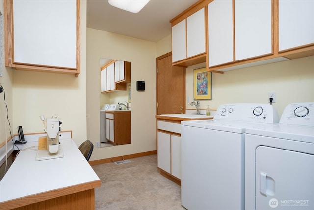 laundry area with cabinet space, baseboards, visible vents, independent washer and dryer, and a sink