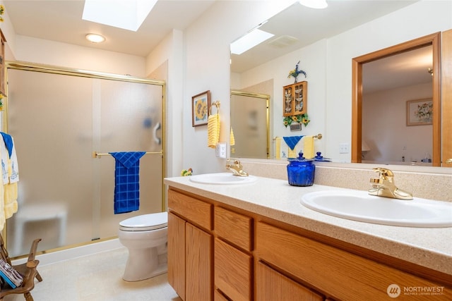 full bathroom featuring double vanity, a skylight, a sink, and a shower stall