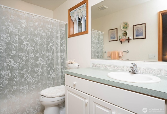 full bathroom featuring toilet, visible vents, a shower with shower curtain, and vanity