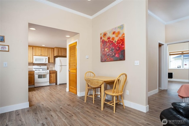 dining room with baseboards, crown molding, and wood finished floors