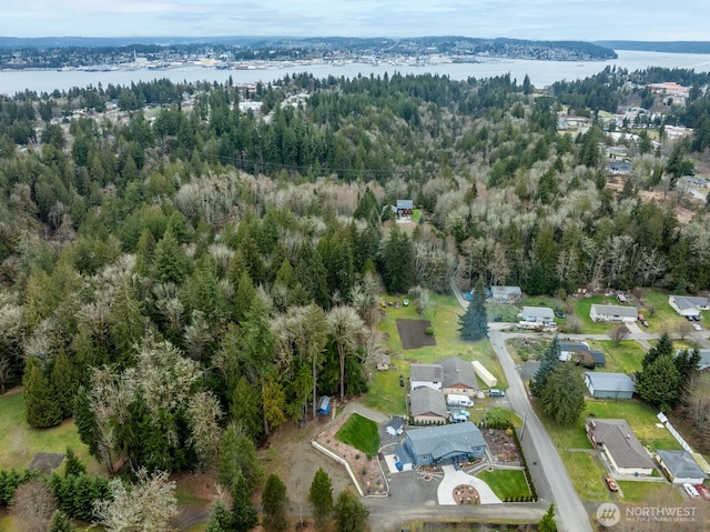 aerial view featuring a forest view and a water view