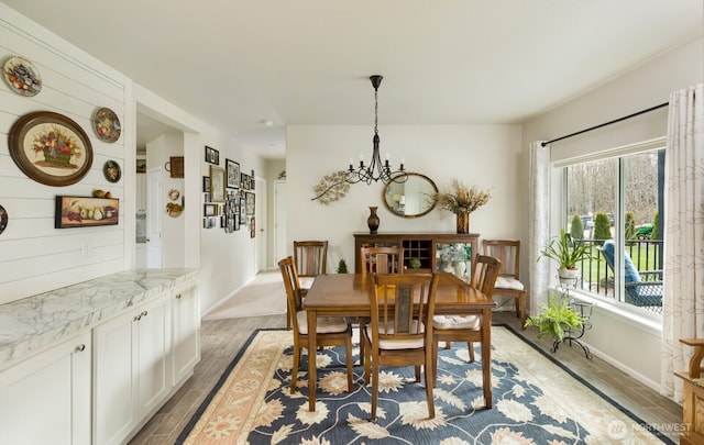 dining room featuring a notable chandelier, baseboards, and light wood-style floors