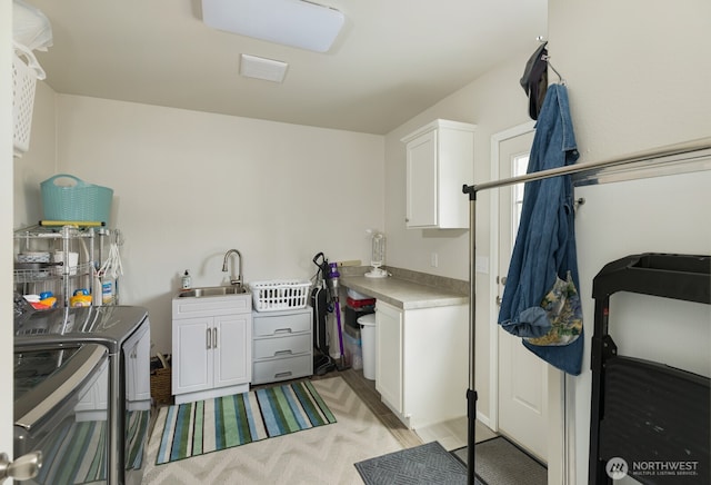 washroom featuring cabinet space, a sink, and washing machine and clothes dryer