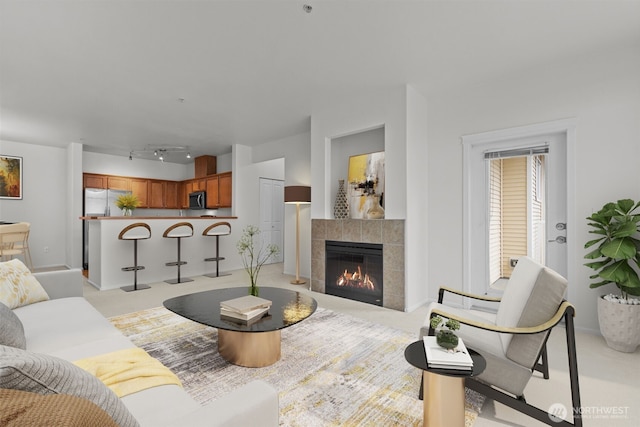 living area with light carpet, track lighting, and a tile fireplace