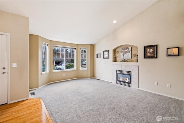 unfurnished living room featuring visible vents, baseboards, carpet flooring, and a tile fireplace