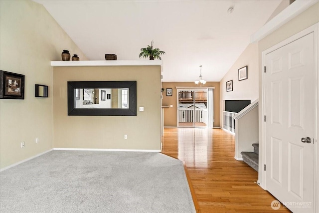 living room with an inviting chandelier, lofted ceiling, stairway, and baseboards