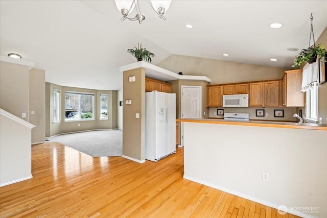 kitchen featuring open floor plan, light wood-type flooring, lofted ceiling, a peninsula, and white appliances