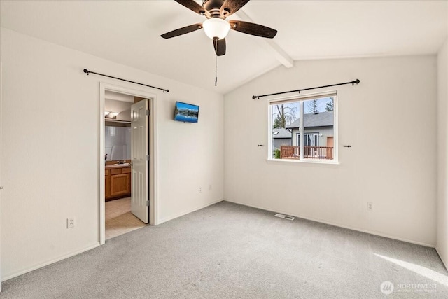 unfurnished bedroom featuring visible vents, ensuite bathroom, light colored carpet, ceiling fan, and vaulted ceiling with beams