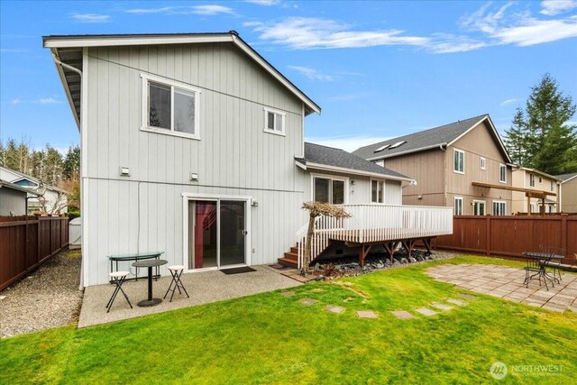 back of property with a patio, a fenced backyard, a lawn, and a wooden deck