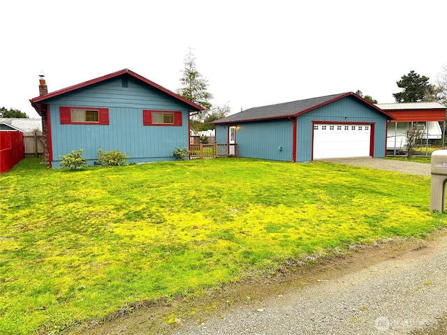 exterior space featuring a garage, a lawn, and fence